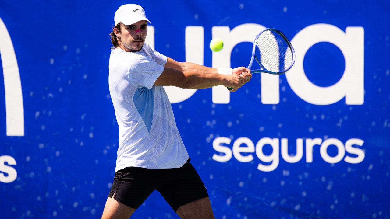 Tenista compete num jogo de ténis contra o fundo azul da UNA Seguros