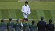 Alcaraz exibe troféu em Wimbledon perante observadores ilustres.
