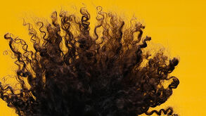 Cabelo encaracolado e volumoso destaca-se num fundo amarelo vibrante