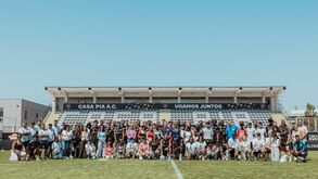 Grupo de pessoas junta-se no campo de futebol do Casa Pia A.C