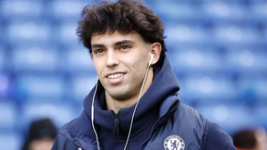 João Félix, jogador do Chelsea, sorri com um casaco do clube