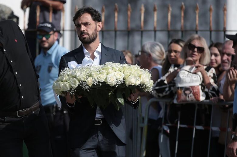 Bernardo Silva carrega coroa de flores brancas