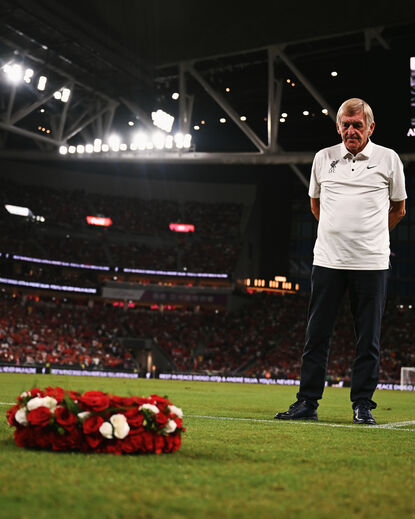 Kenny Dalglish presta homenagem no estádio de futebol, com coroa de flores
