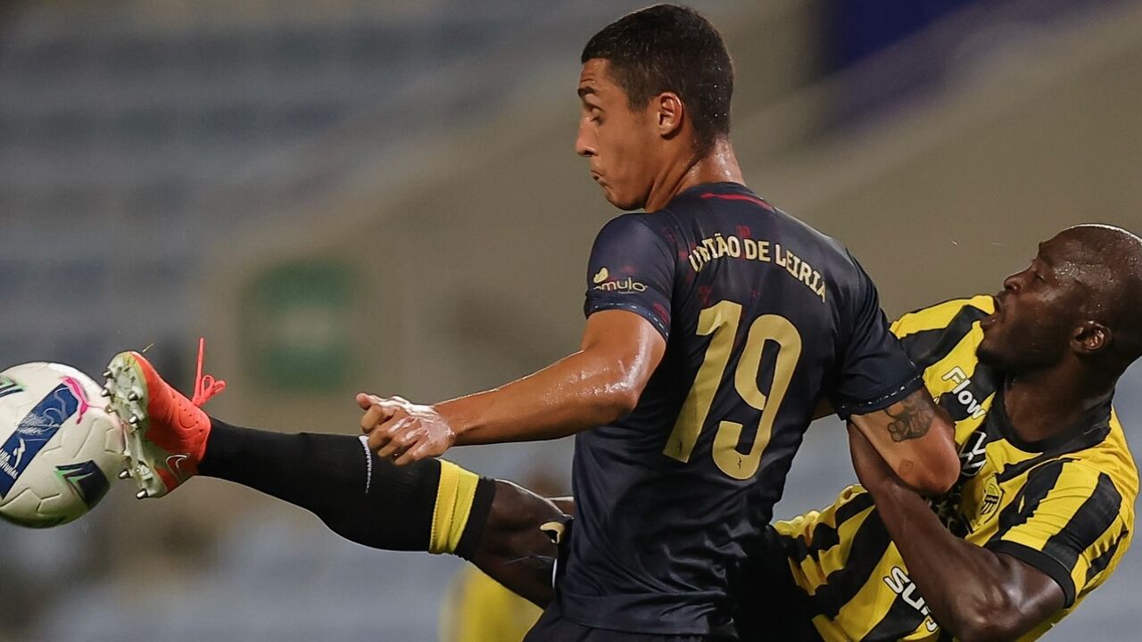 Futebolistas em disputa de bola durante o jogo