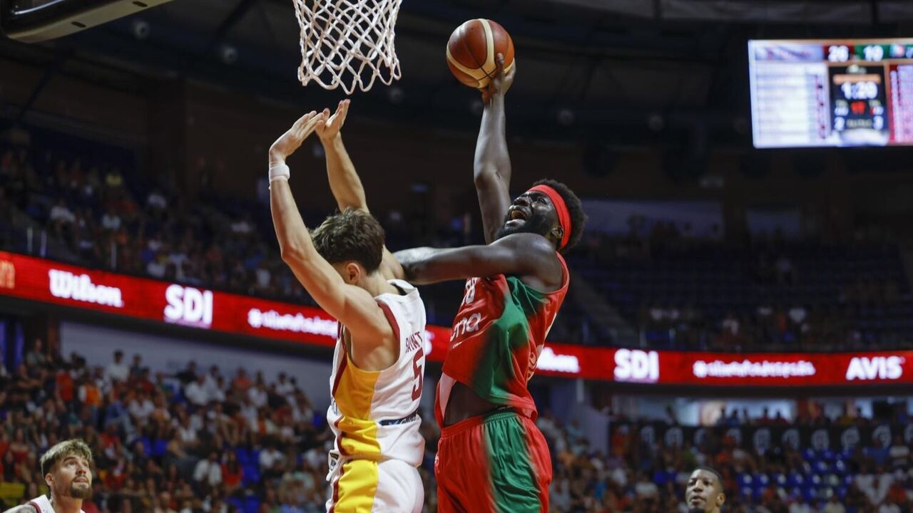 Jogo de basquetebol com dois jogadores em ação e público nas bancadas