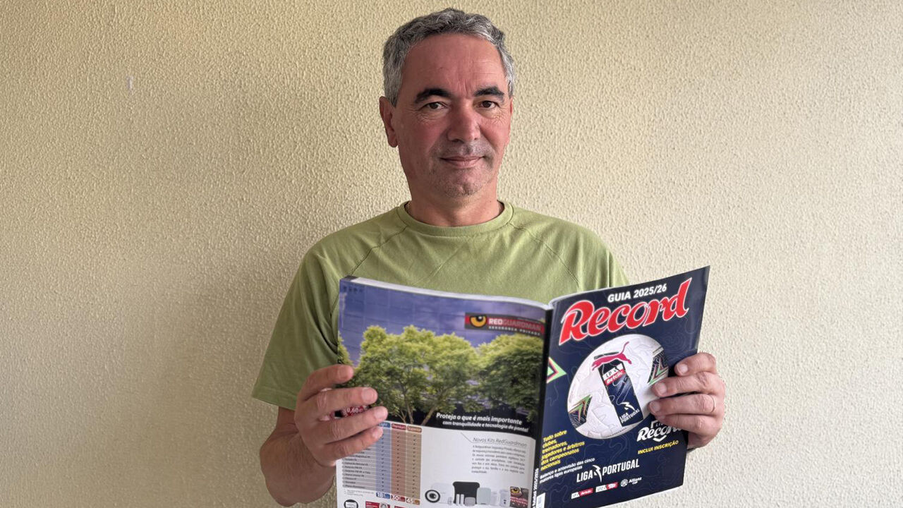 Homem lê guia Record da Liga Portugal 2025/26, com foco na promoção de jovens talentos