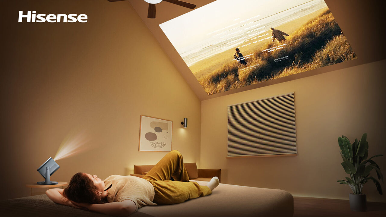 Mulher relaxa enquanto assiste a filmes projetados pelo mini projetor laser Hisense C2