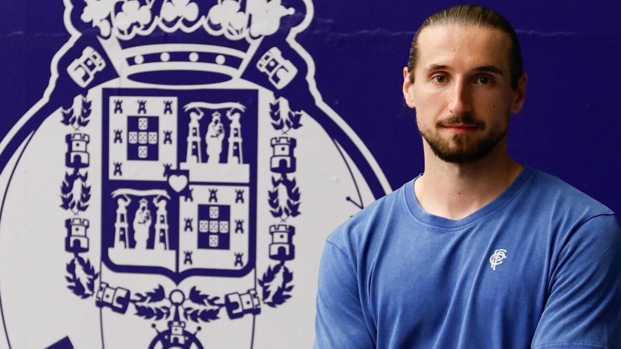 Atleta posa com o símbolo do Futebol Clube do Porto ao fundo