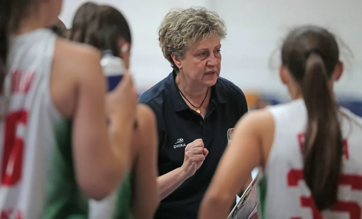 Treinadora de basquetebol dá instruções à equipa.

