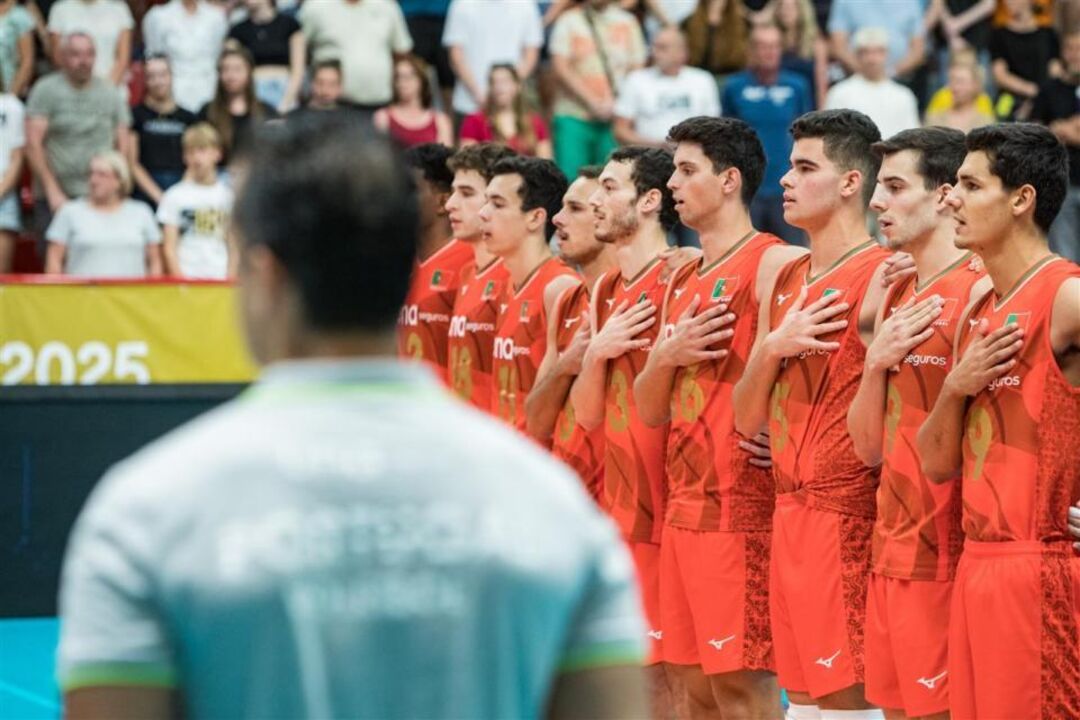 Jogadores de voleibol de Portugal perfilados com a mão no peito durante o hino