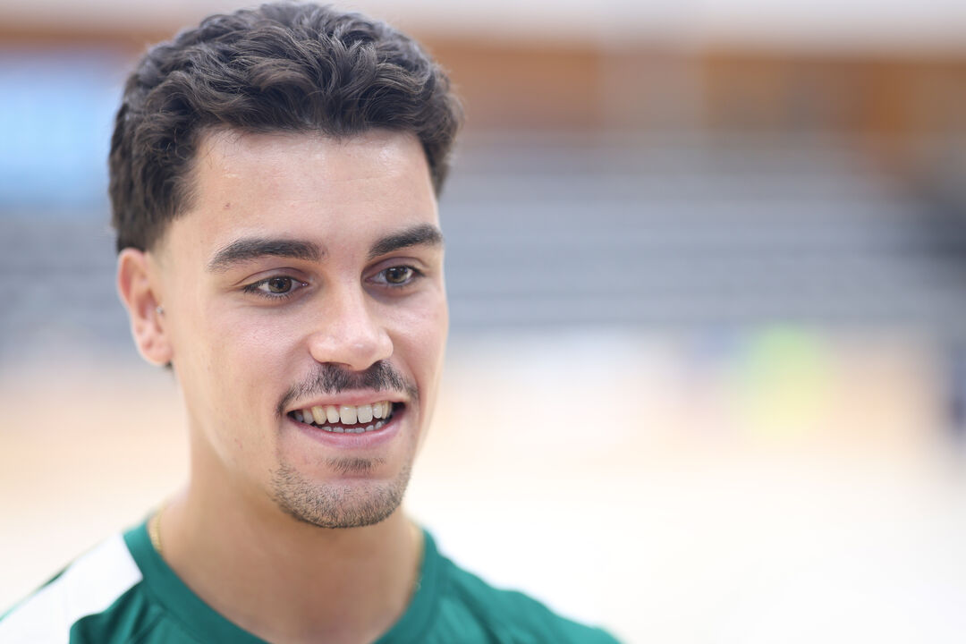 Retrato de jogador sorridente com equipamento desportivo verde