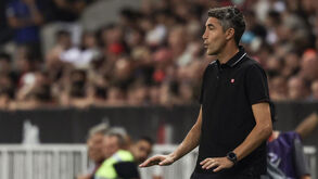 Treinador observa o jogo da equipa no estádio