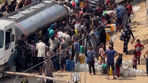 Palestinianos fazem fila para recolher água potável de camião na Faixa de Gaza   