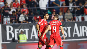 Jogadores do Benfica em campo, com equipamento vermelho
