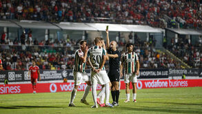 Árbitro mostra cartão amarelo durante jogo E. Amadora-Benfica
