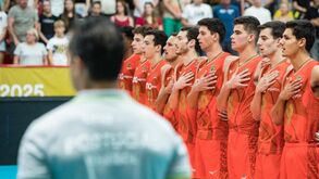 Jogadores de voleibol de Portugal perfilados com a mão no peito durante o hino