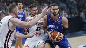 Arturs Kurucs e Rolands Smits, da Letónia, disputam a bola com Marko Guduric, da Sérvia