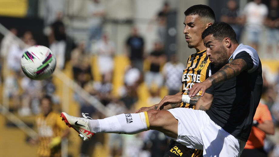 Silvério (em segundo plano) disputa a bola com Salvador Agra