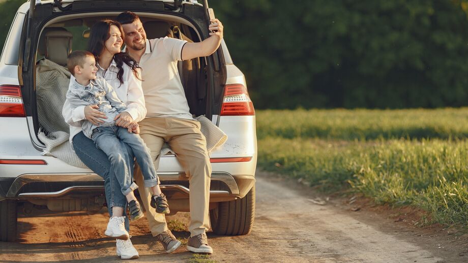 Família faz selfie durante viagem de carro. Alugar carro oferece liberdade e flexibilidade nas férias