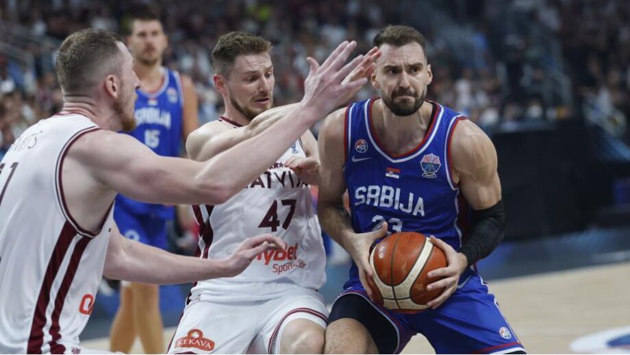 Arturs Kurucs e Rolands Smits, da Letónia, disputam a bola com Marko Guduric, da Sérvia