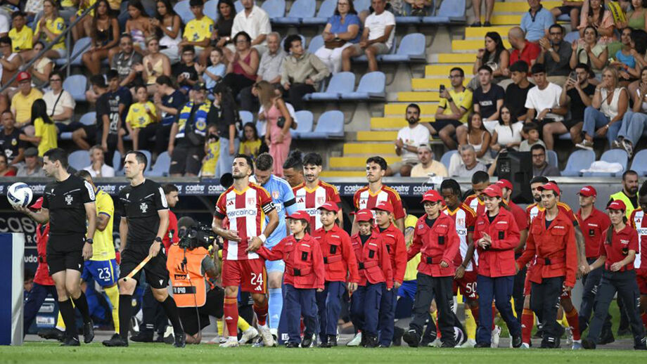 Jogadores de futebol entram em campo de mãos dadas com bombeiros
