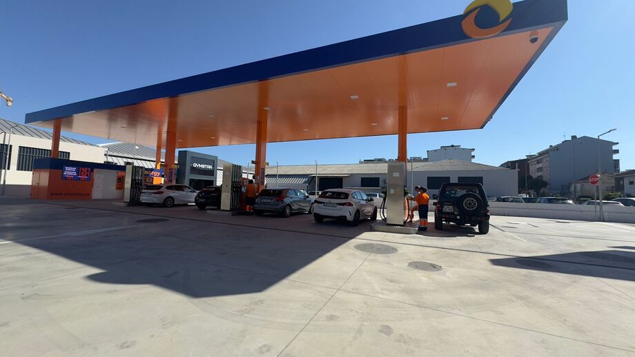 Posto de combustível com carros a abastecer e funcionários no local