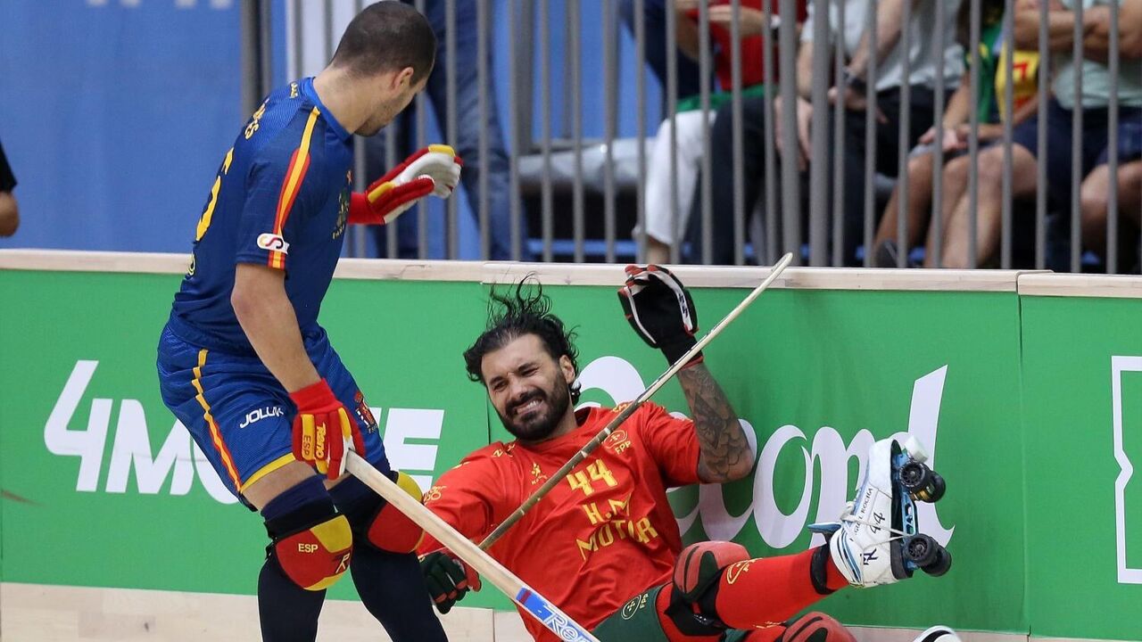 Jogo de hóquei em patins: jogador português no chão após disputa com atleta espanhol
