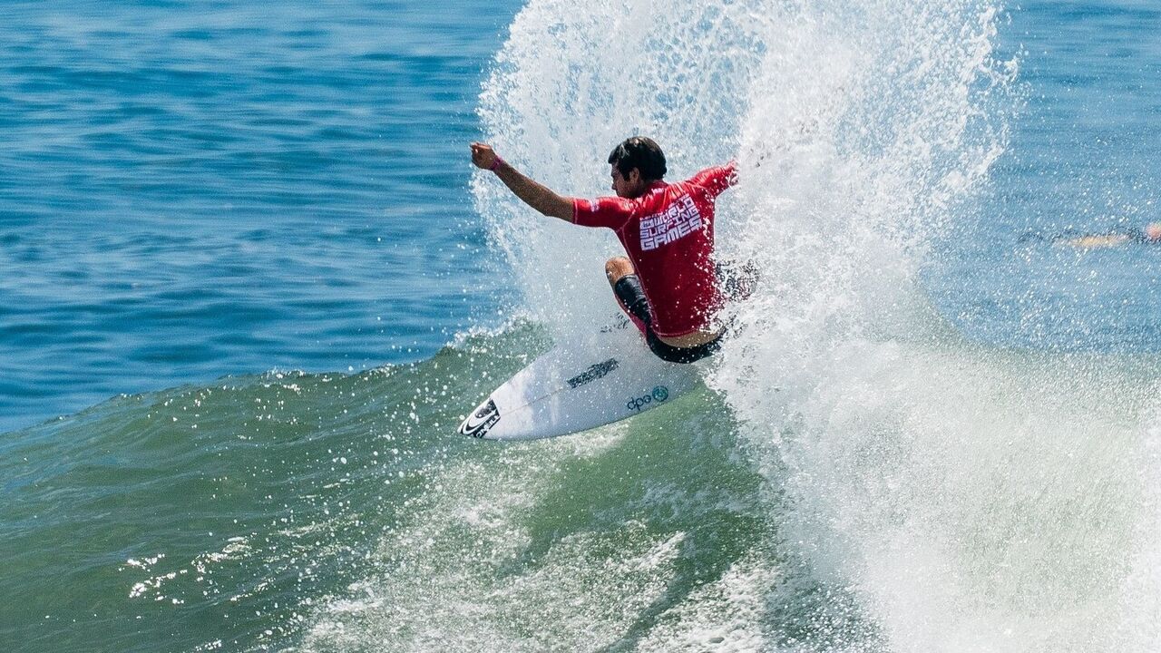 Surfista compete nos World Surfing Games em cima de uma prancha