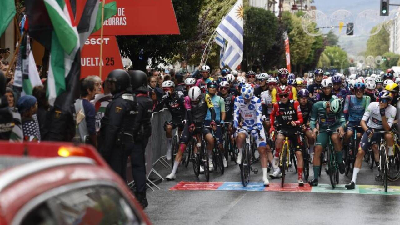 Ciclistas e protestantes antes da partida para a 17.ª etapa da Vuelta