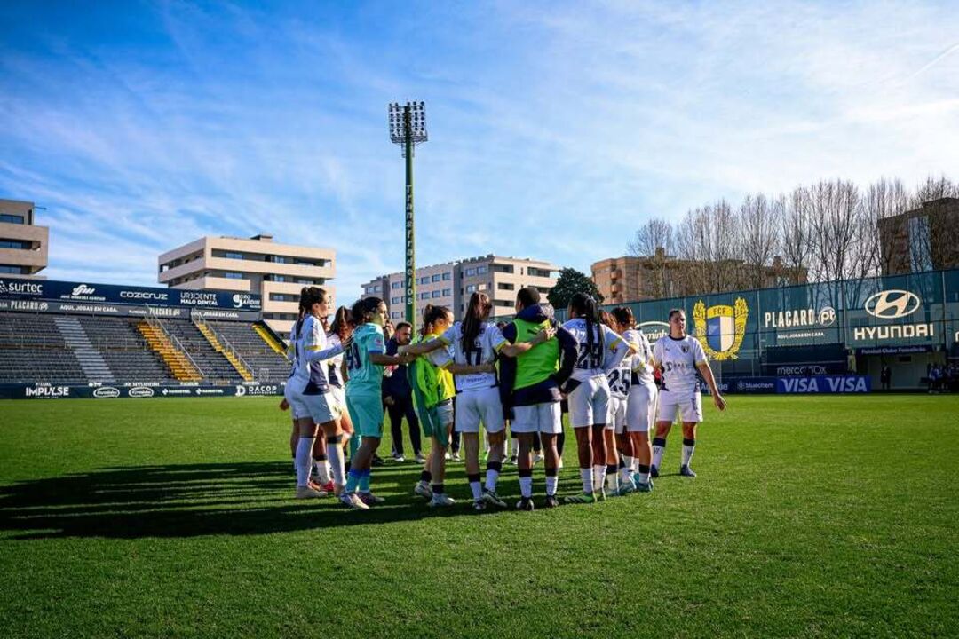 Equipa feminina de futebol unida em campo para disputar a partida