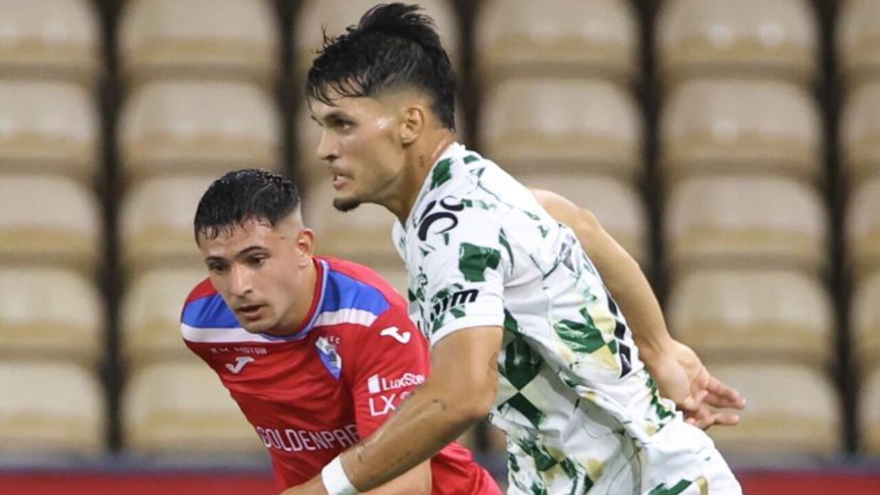 Dois jogadores de futebol competem pela posse de bola durante o jogo