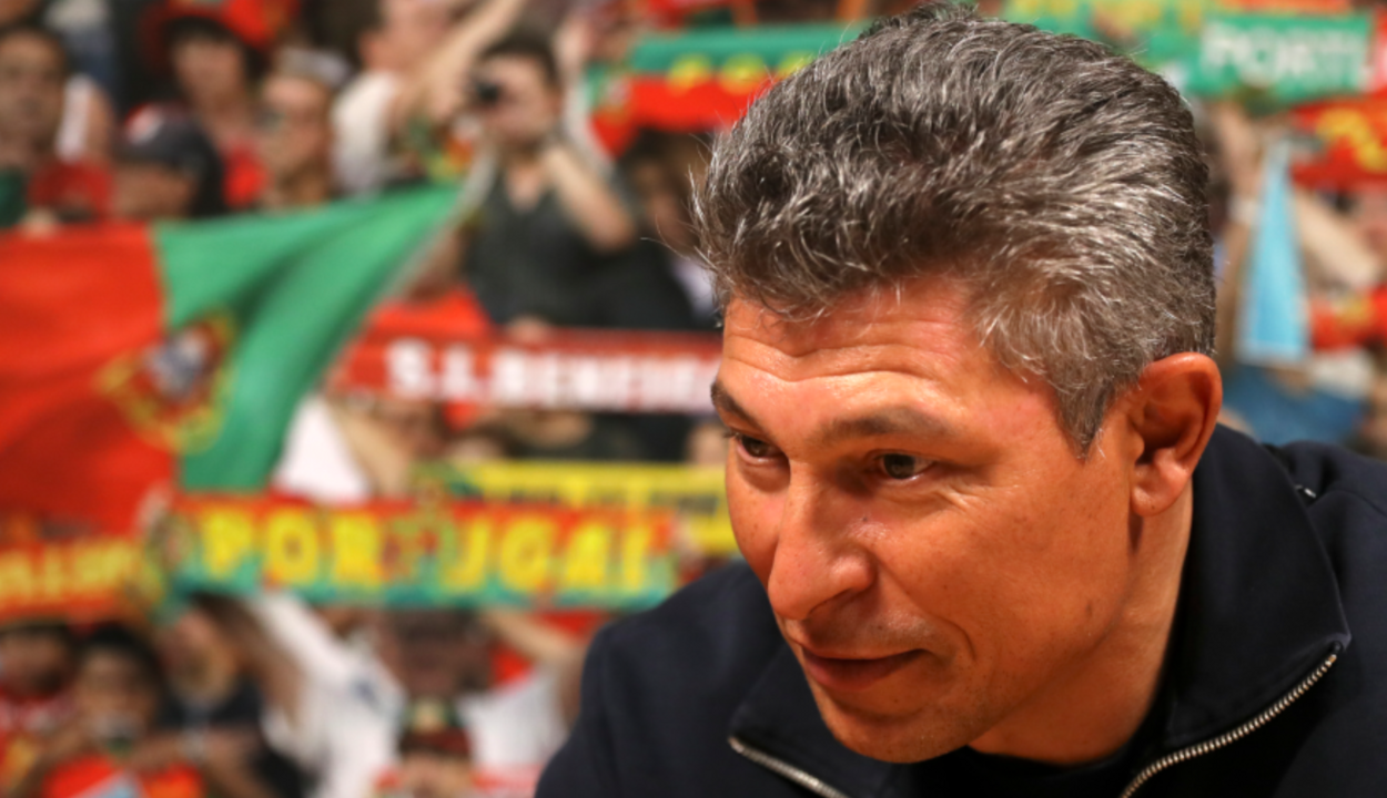 Treinador com adeptos portugueses no fundo