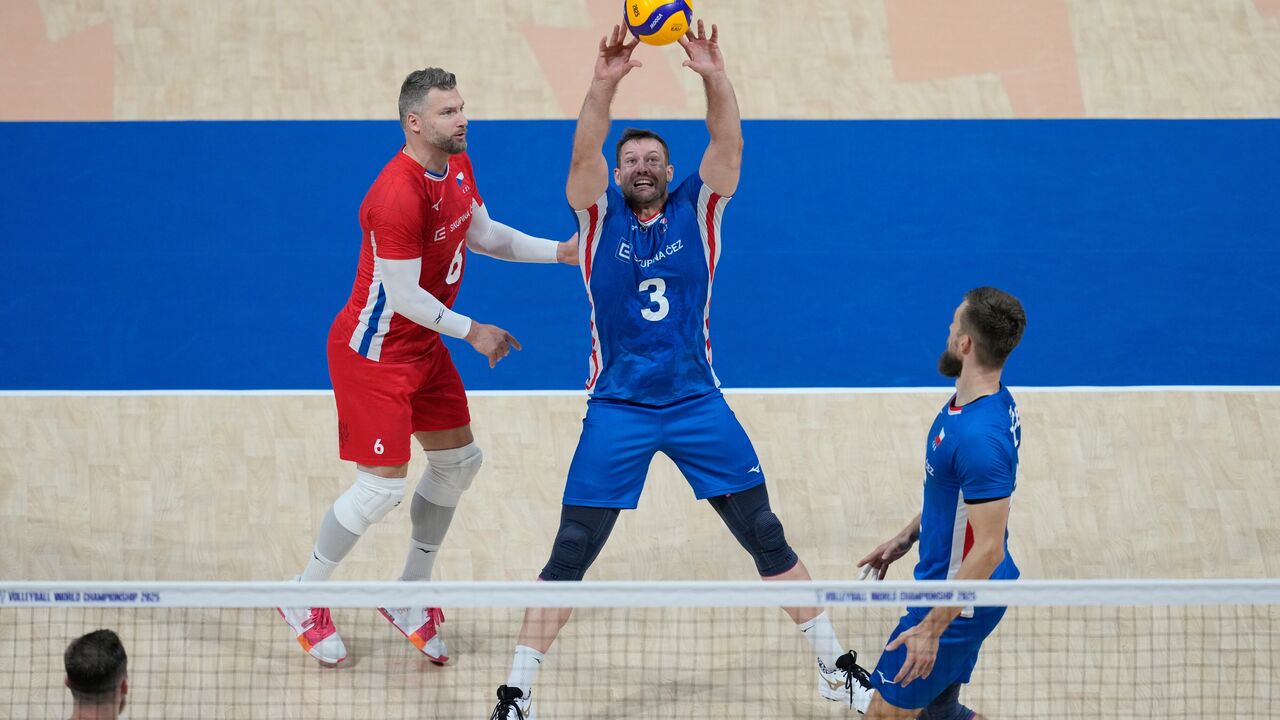 Um jogador de voleibol prepara-se para atacar a bola num jogo