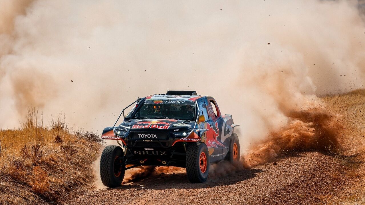 Carro de corrida Toyota Hilux no Dakar com poeira