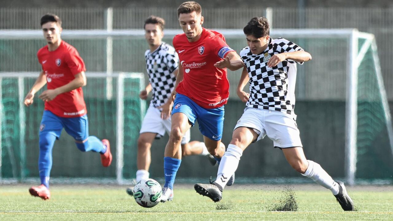 Jogo de futebol com jogadores em ação no relvado