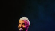 Humorista atua em palco com um microfone