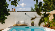 Piscina calma com almofadas e plantas num ambiente relaxante