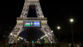 Pomba que representa paz a separar bandeiras de Israel e da Palestina projetada na Torre Eiffel