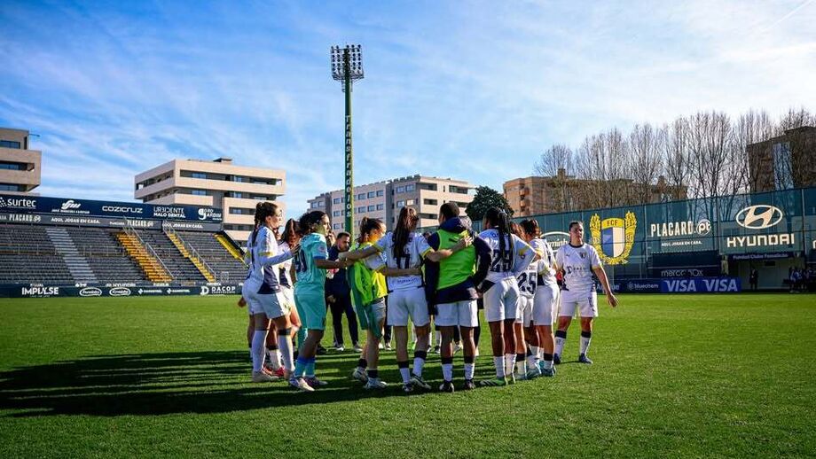 Equipa feminina de futebol unida em campo para disputar a partida