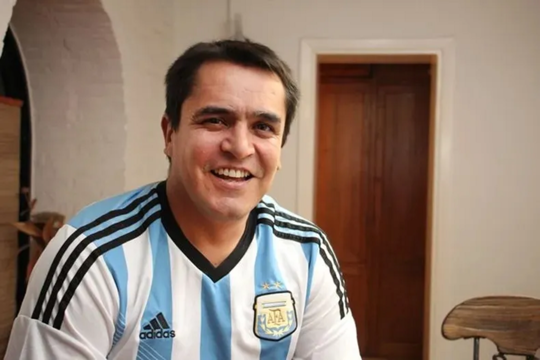 Homem sorri com uma camisola da Argentina
