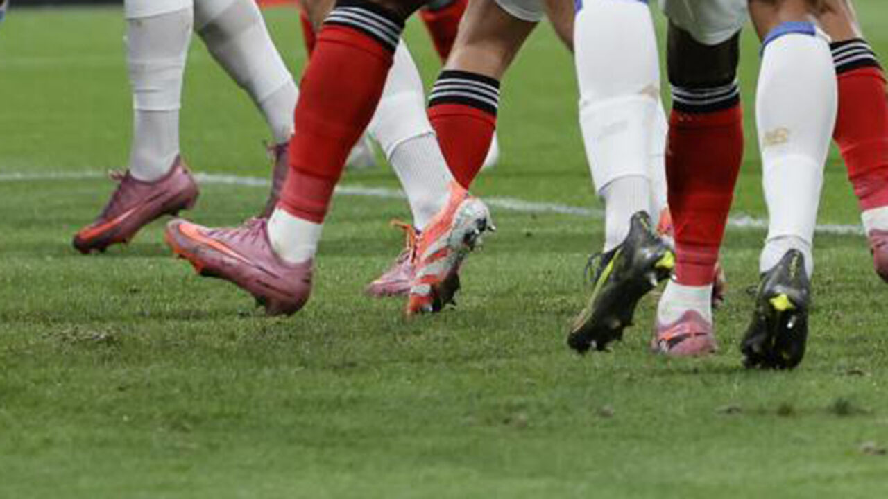 Futebolistas em campo: destaque para as chuteiras coloridas.

