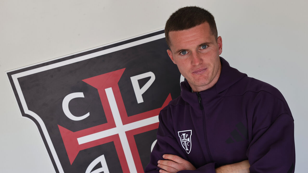 Jérémy Livolant ao lado do escudo do Casa Pia