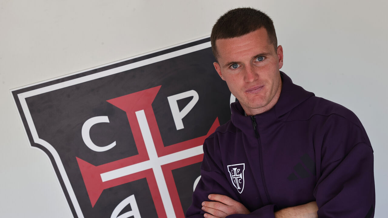 Jérémy Livolant ao lado do escudo do Casa Pia
