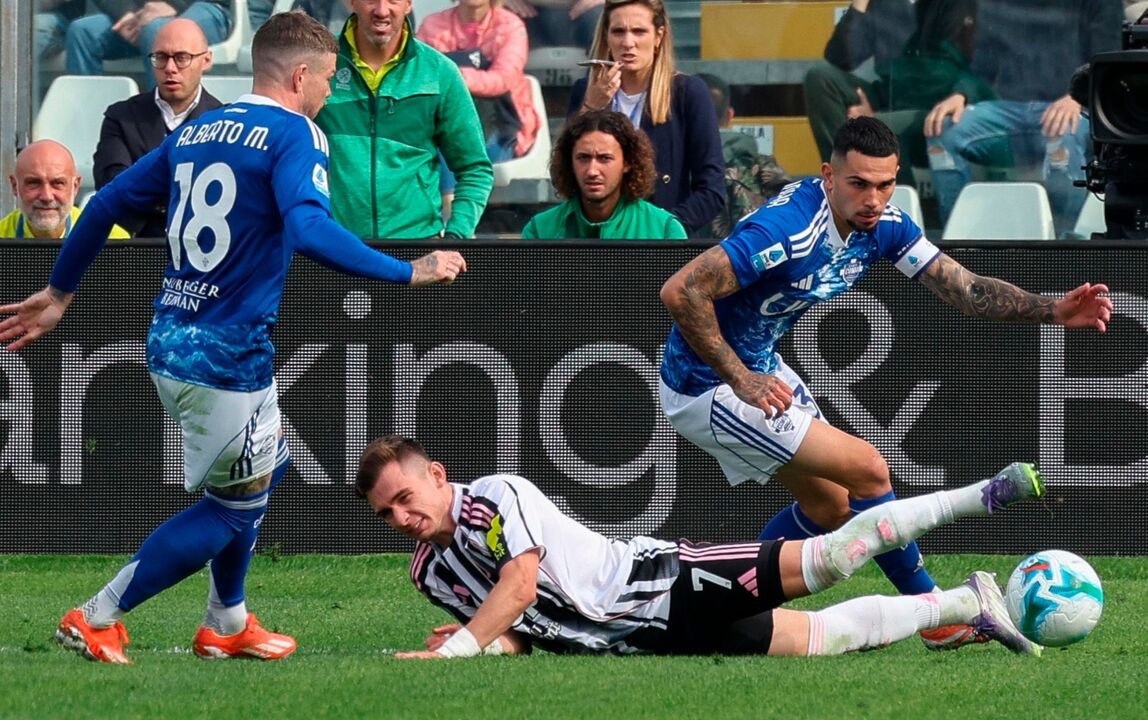 Futebolistas disputam a bola em campo durante um jogo