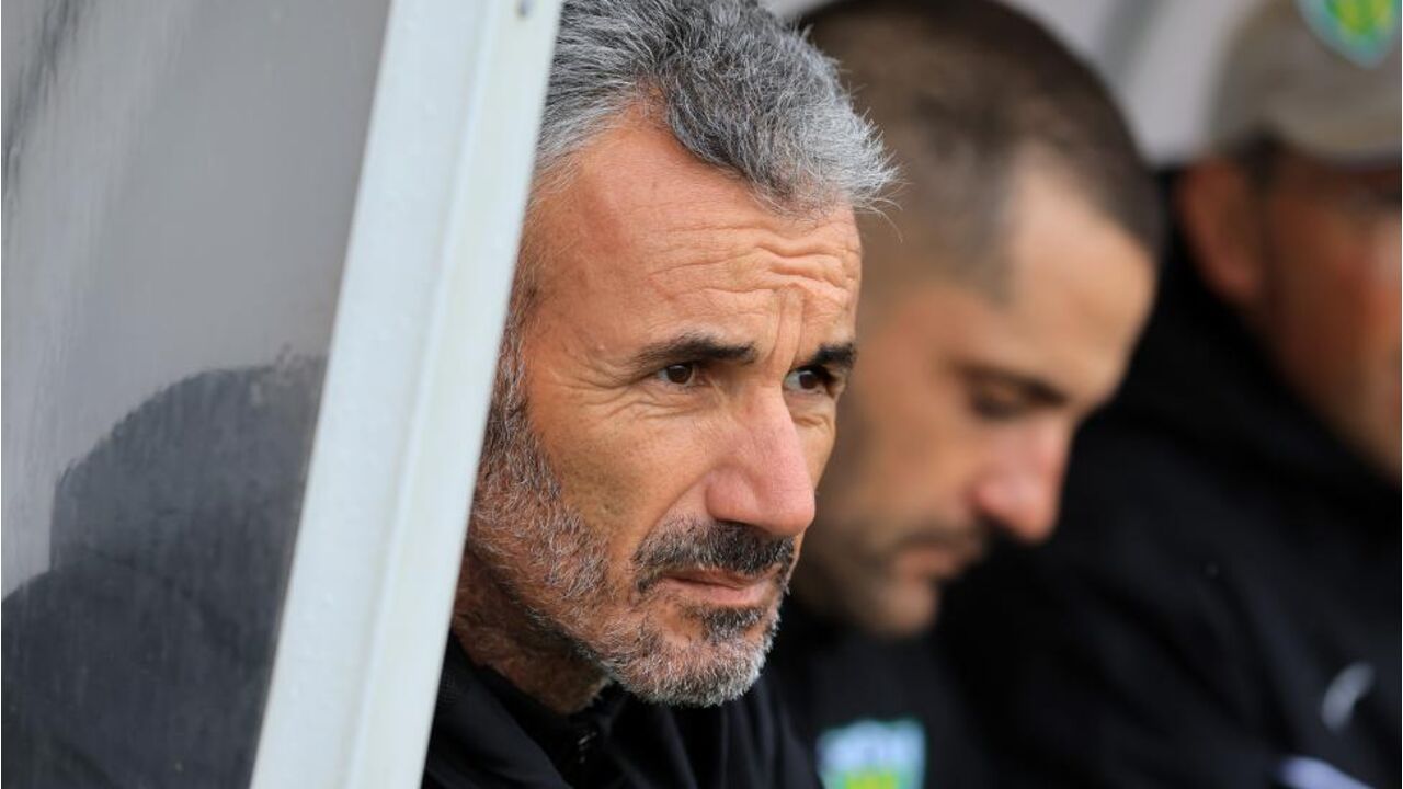 Treinador de futebol acompanha o jogo do banco de suplentes