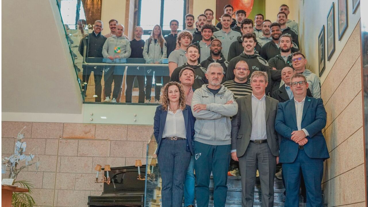 Grupo de pessoas posa nas escadas, incluindo membros de equipa e dirigentes