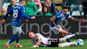 Futebolistas disputam a bola em campo durante um jogo