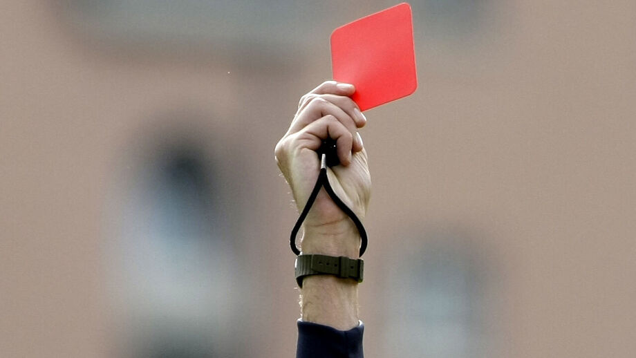 Cartão vermelho na mão de árbitro