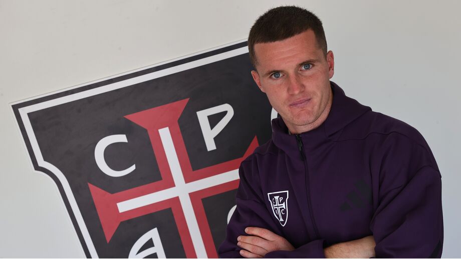 Jérémy Livolant ao lado do escudo do Casa Pia