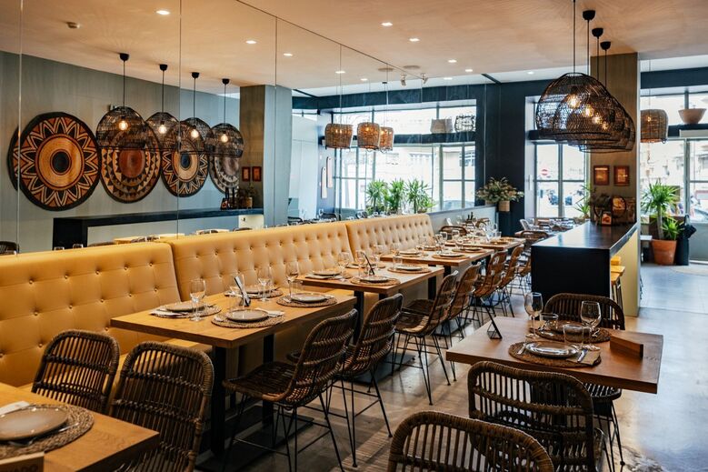 Interior de restaurante com mesas postas e cadeiras de vime